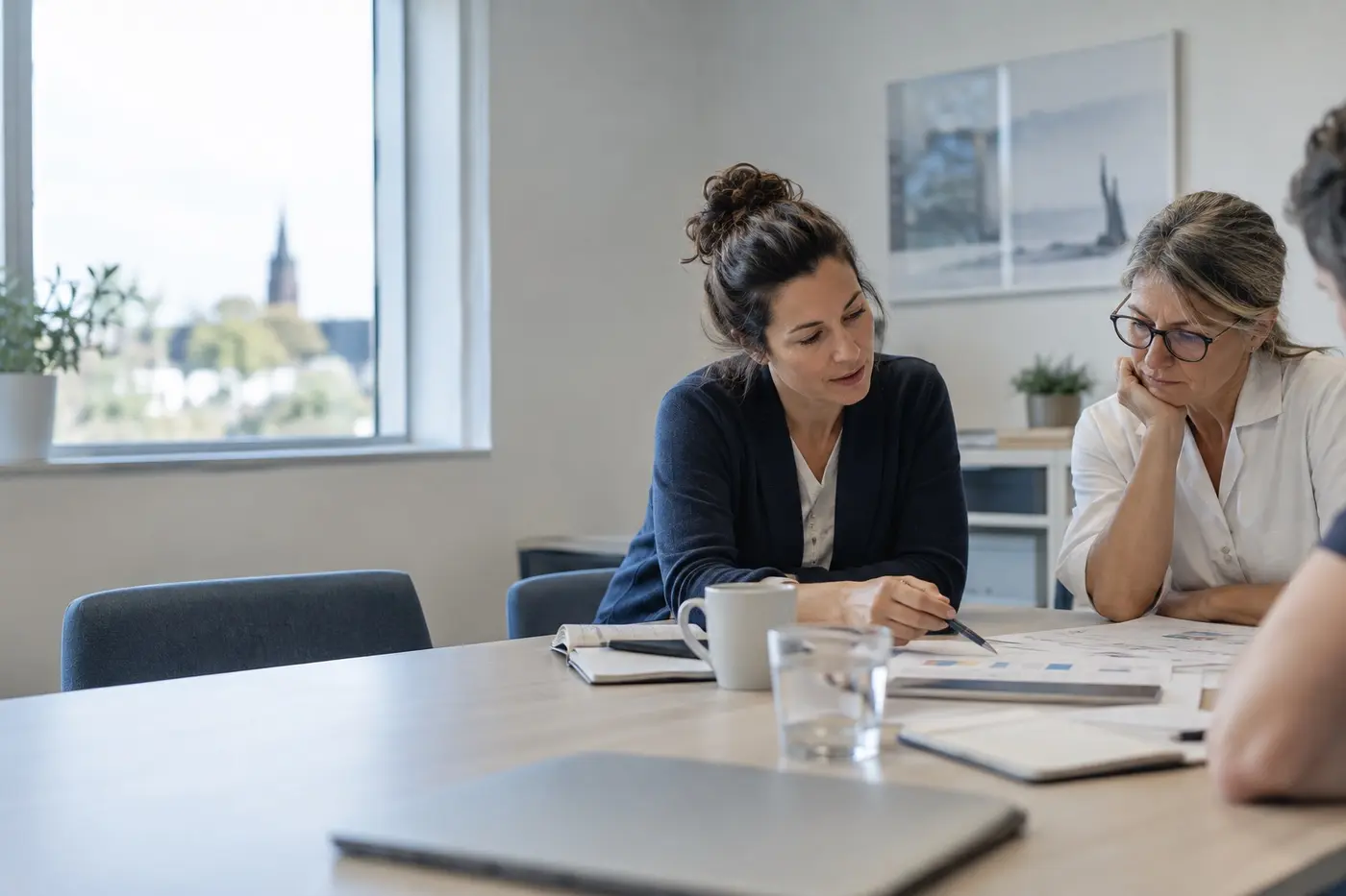 Deux professionnelles examinent un planning ensemble dans une salle de réunion.